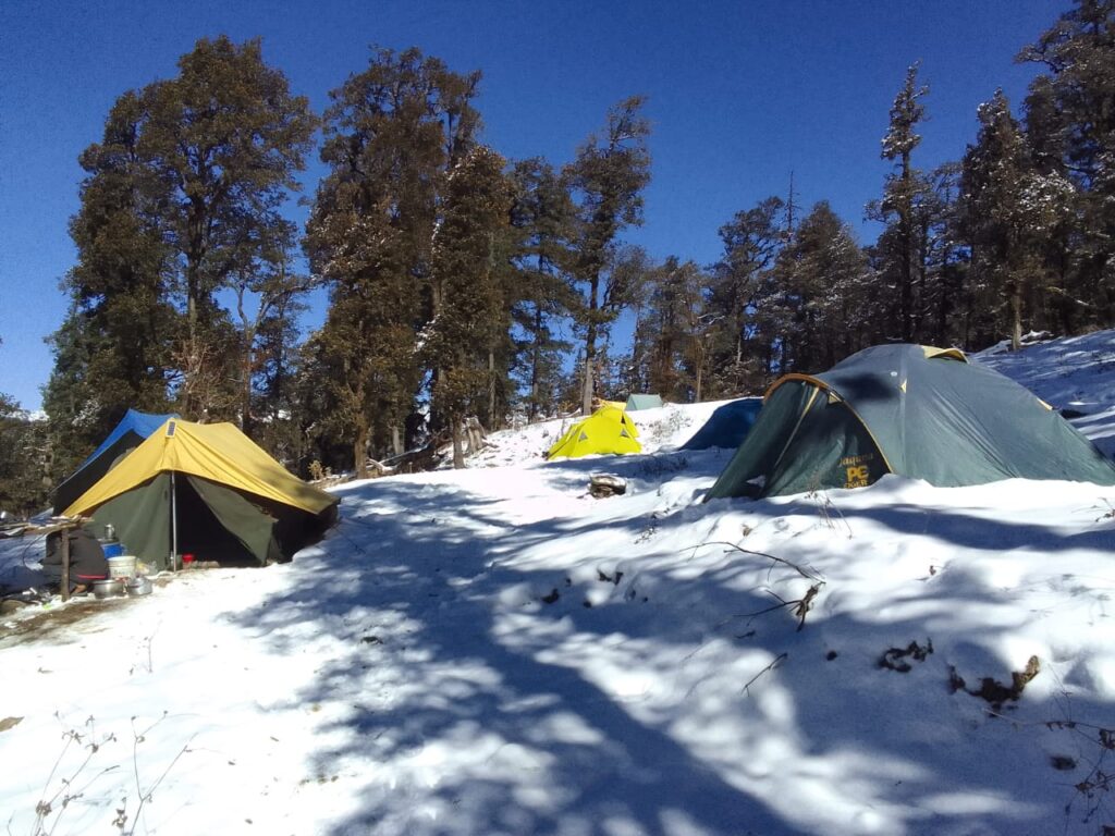 Scenic view of Kedarkantha Base Camp covered in snow with majestic Himalayan peaks in the background